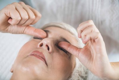 Marma therapy.  Beautiful senior woman lying on massage table and enjoying Ayurveda Eyes Treatment (Urdhaw and Adhoakshi)